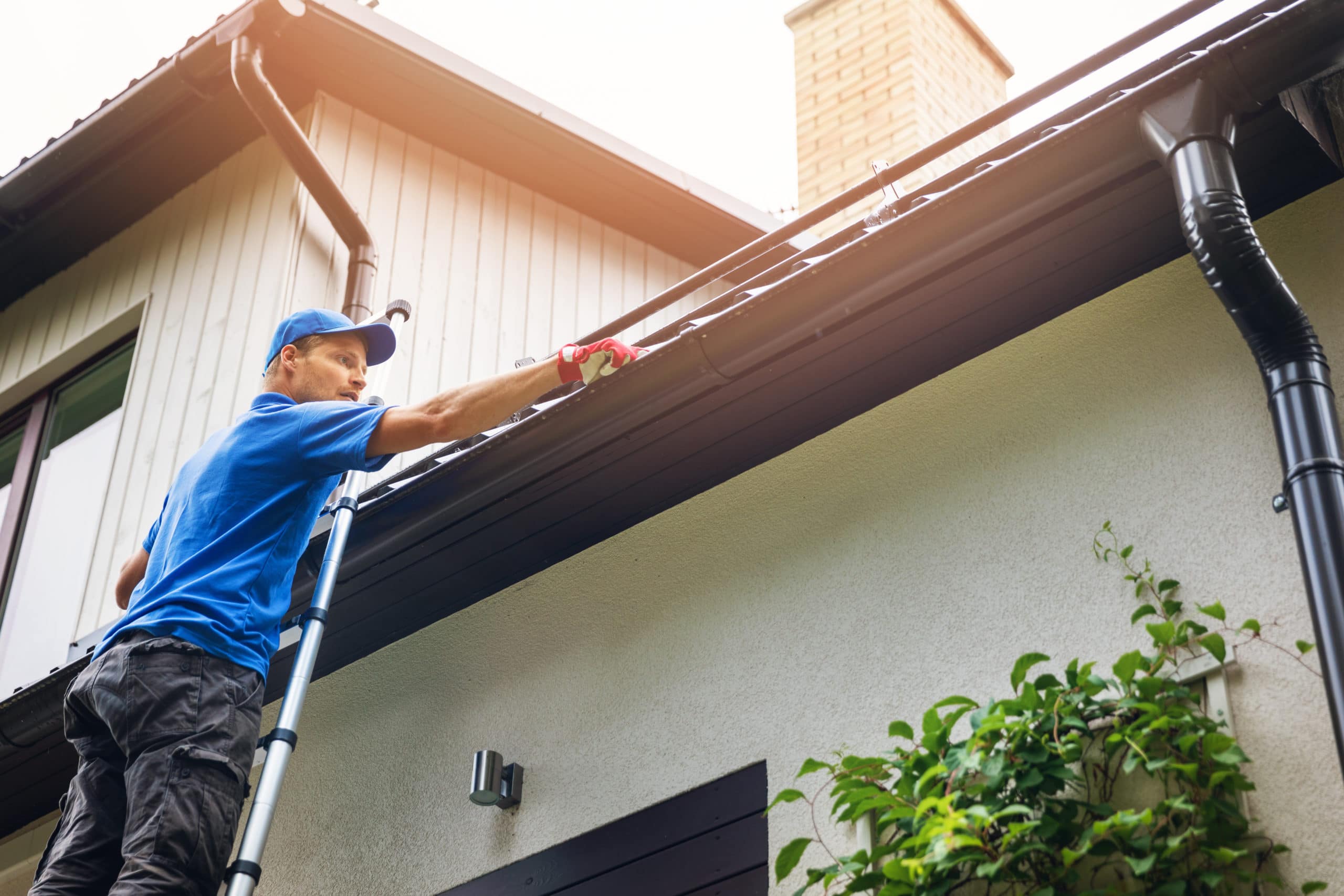 man on ladder | cleaning gutters