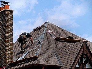 man repairing roof of house | hoa violations
