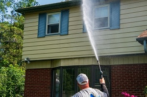 man pressure washing front of a house | 2020 pressure washing prices