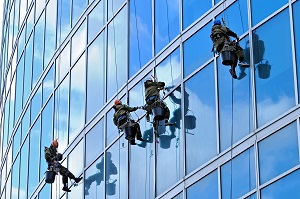 Industrial climbers are washing glass on the facade of a skyscraper | exterior commercial building cleaning
