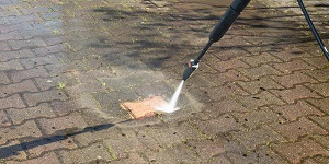Outdoor floor Worker cleaning driveway with a pressure water jet | pressure wash driveway