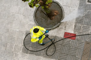 top view of a worker cleaning the street sidewalk with high pressure water jet | pressure wash the patio