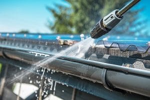 pressure washing gutter of house | residential cleaning services