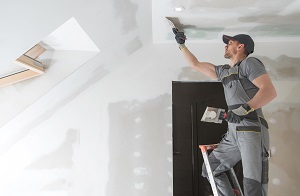 man finishing and patching drywall walls | property maintenance services