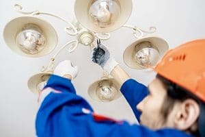 worker fixing lights | building maintenance services