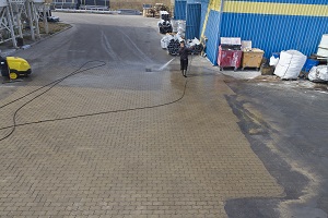 man pressure washing outside warehouse | commercial warehouse pressure washing