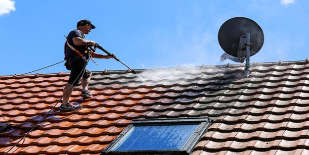 man on roof | roof pressure washing